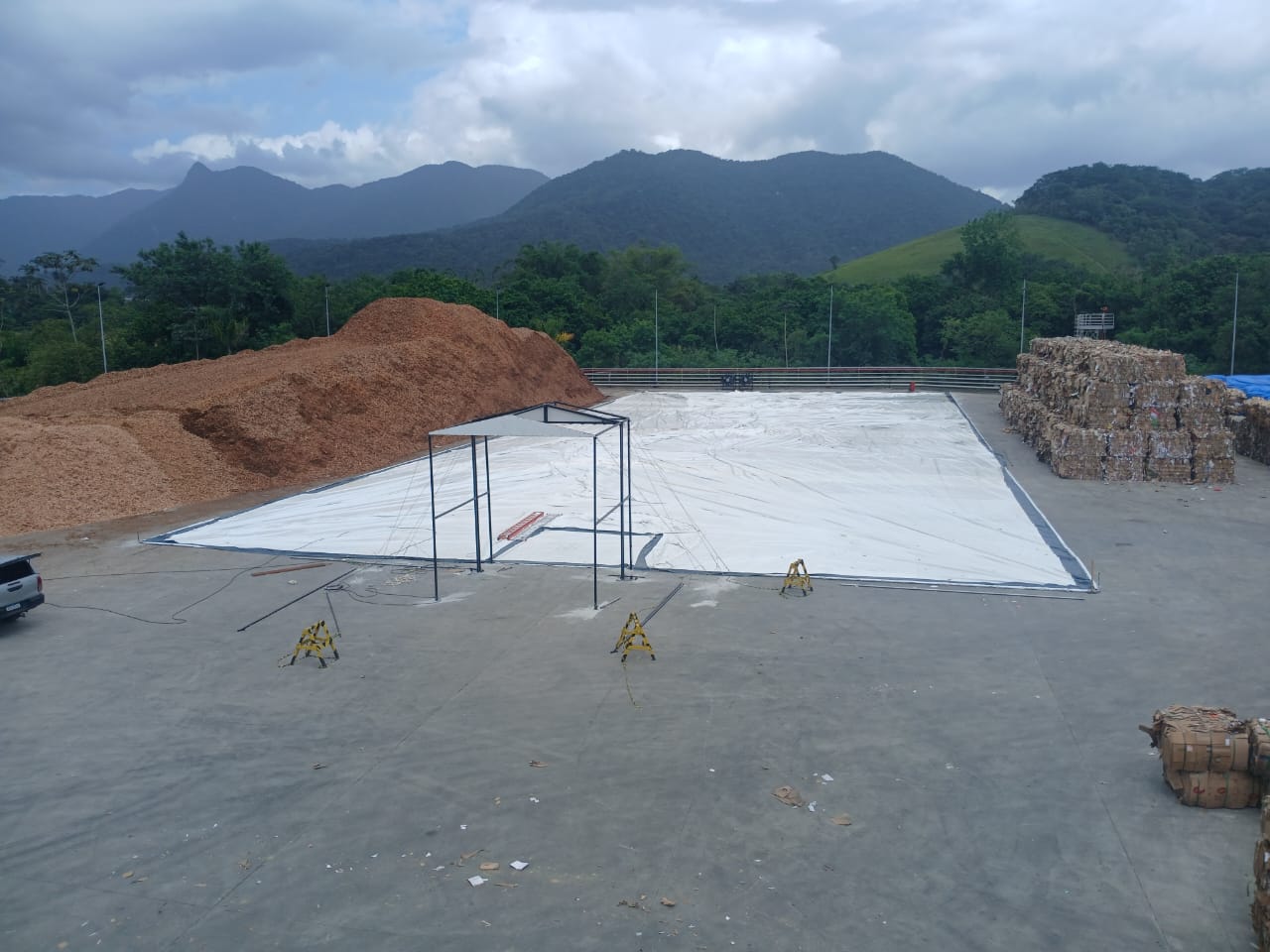 Biomassa exposta ao lado de uma montagem de galpão inflável.